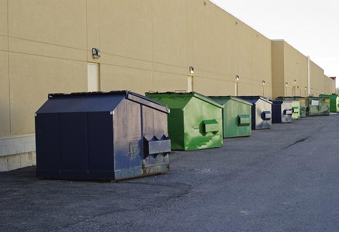 a row of industrial dumpsters at a construction site in Albert City